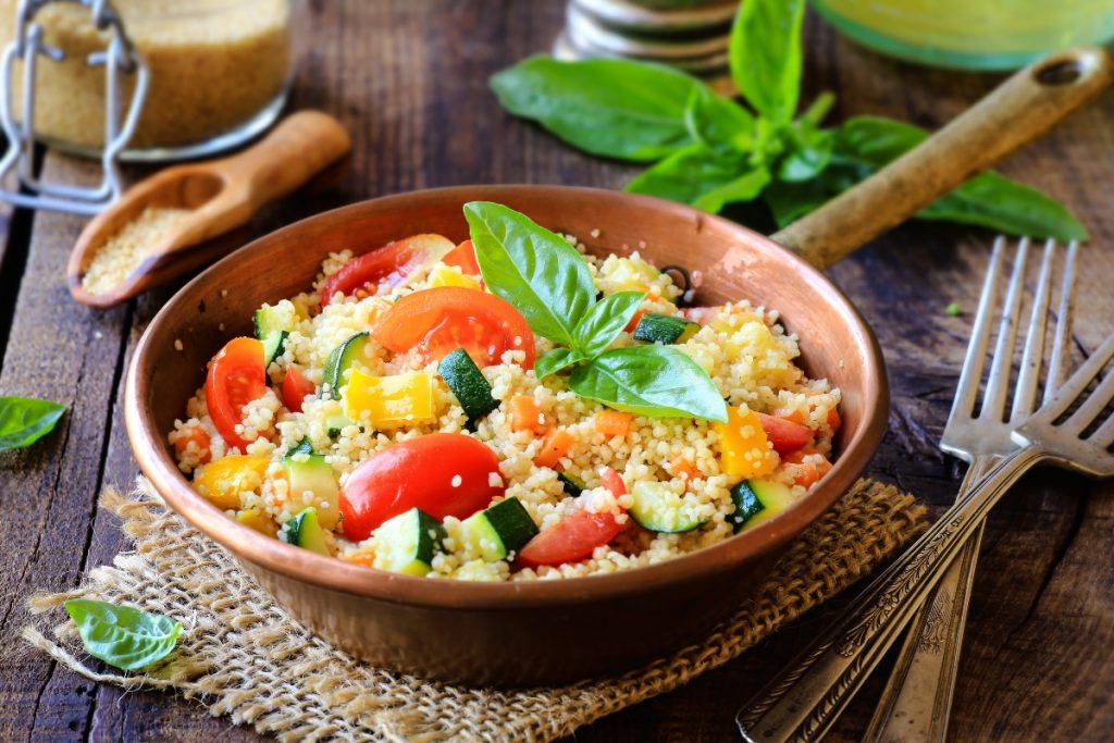 Cous cous di verdure: la ricetta semplice e veloce 1 padella con manico piena di cous cous di verdure e foglie di menta