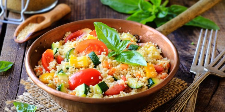 padella con manico piena di cous cous di verdure e foglie di menta