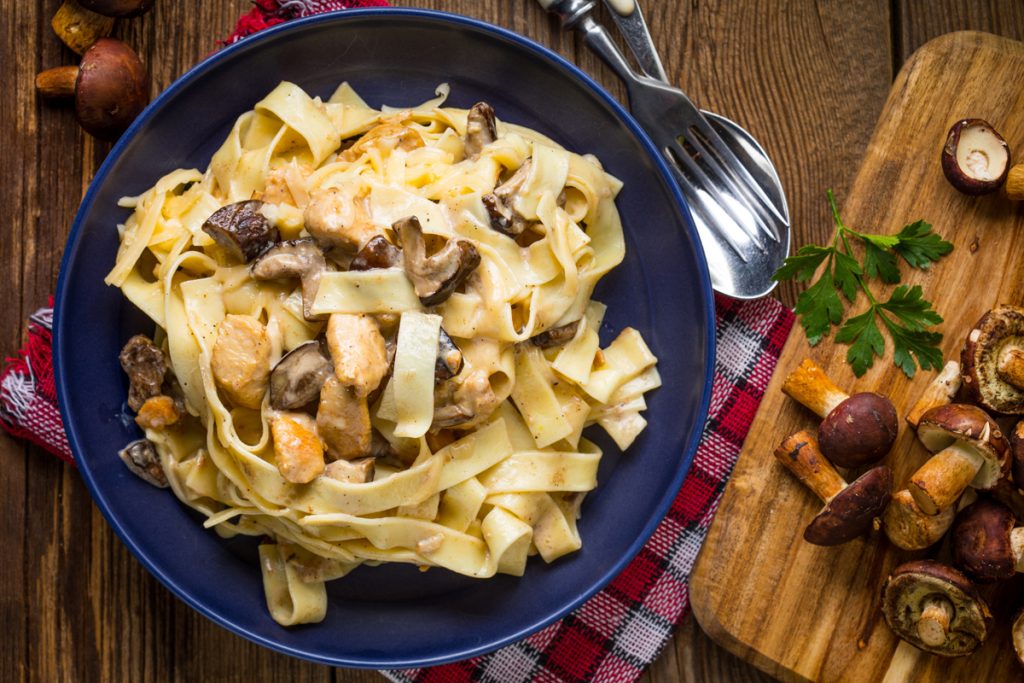 Tagliatelle ai funghi porcini, un primo tradizionale, veloce da preparare 5 piatto blu con tagliatelle ai funghi e vassoio con porcini