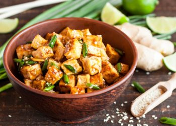 scodella con pezzetti di tofu e verdure su base di legno