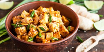 scodella con pezzetti di tofu e verdure su base di legno