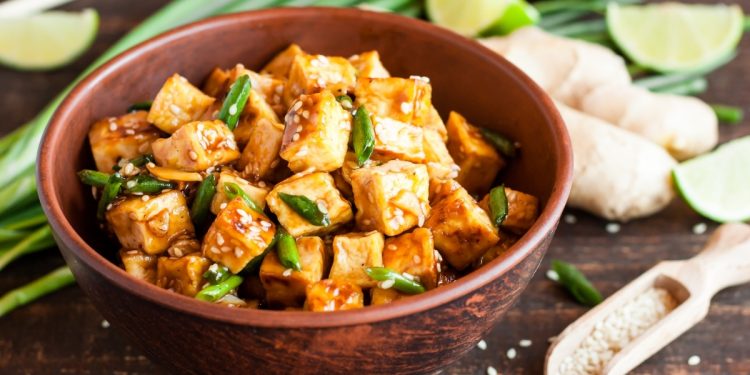 scodella con pezzetti di tofu e verdure su base di legno