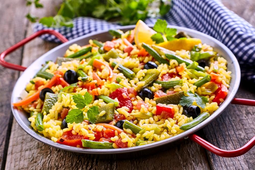 piatto con paella vegetariana ricca di verdure sul tavolo