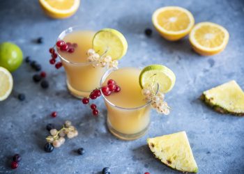 due bicchieri di cocktail analcolico Fruit Punch, ribes, fette e spicchi di limone