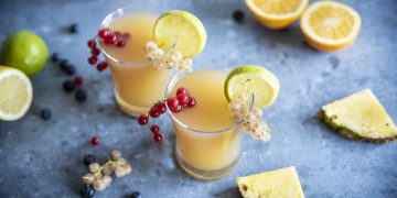 due bicchieri di cocktail analcolico Fruit Punch, ribes, fette e spicchi di limone