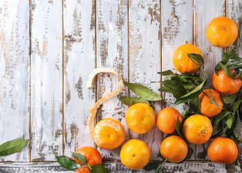 alcune clementine sparse su un tavolo di legno bianco