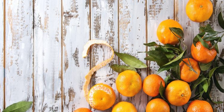 alcune clementine sparse su un tavolo di legno bianco