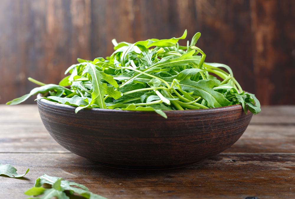 Della rucola dentro una ciotola in legno