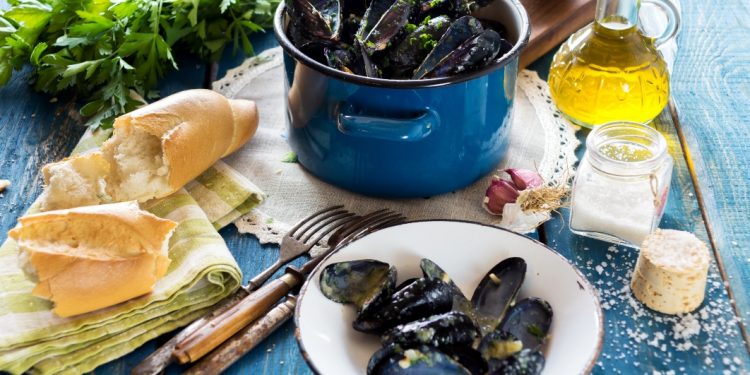 Su un tavolo c'è tutto l'occorrente per pulire le cozze