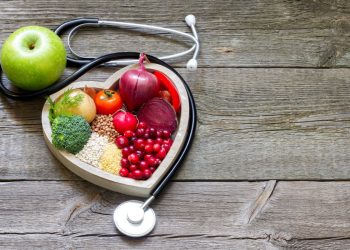 come abbassare il colesterolo: un contenitore a forma di cuore con alimenti salutari