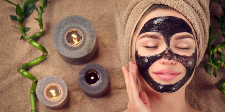 una donna rilassata con la black mask applicata sul viso