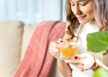 tisana sgonfia pancia: una donna che beve una tisana calda