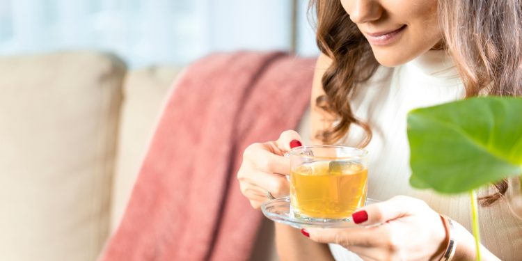 tisana sgonfia pancia: una donna che beve una tisana calda