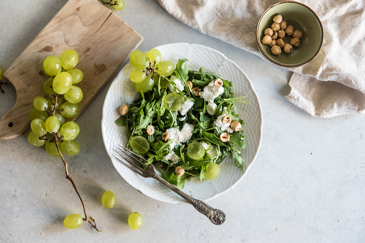 ricette con nocciole, insalata di rucola, nocciole, uva e caprino