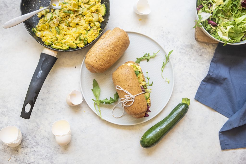 Panino con uova strapazzate alle zucchine e insalate