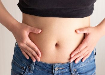 una giovane donna che si tocca la pancia perché soffre di intestino irritabile