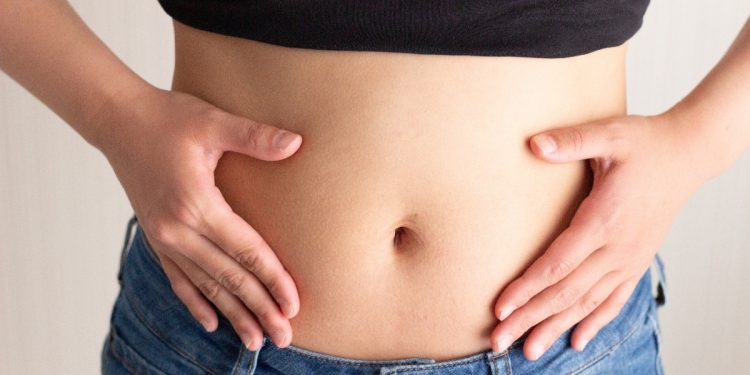 una giovane donna che si tocca la pancia perché soffre di intestino irritabile