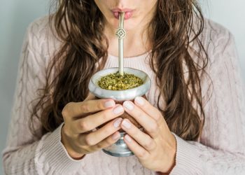 una giovane donna che bene del tè mate