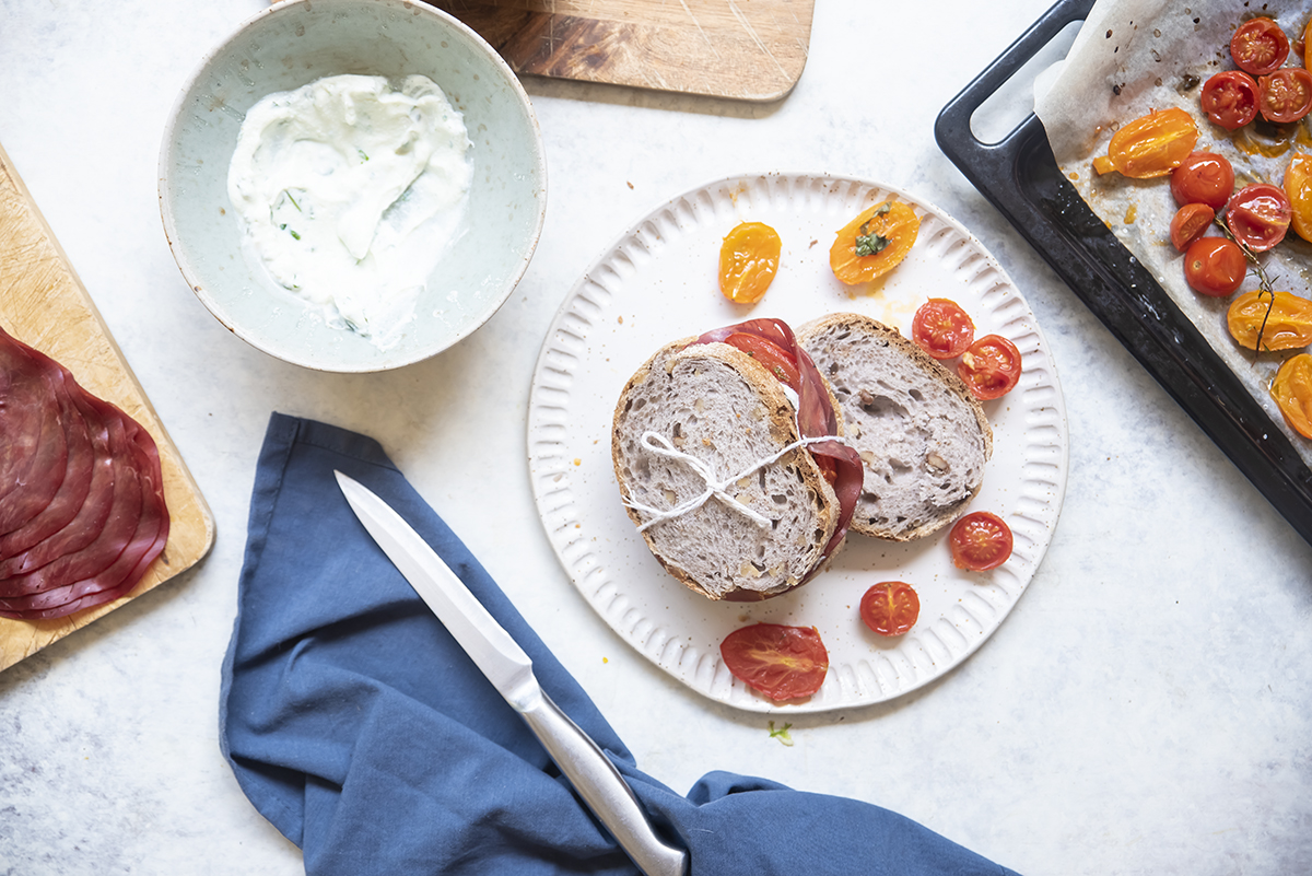 Panino con bresaola, ricotta al basilico e pomodori confit