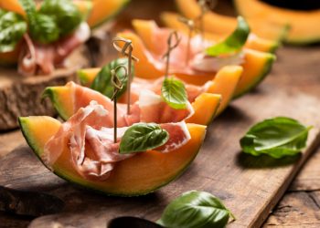 prosciutto e melone: alcune fette di melone con il prosciutto e una foglia di basilico