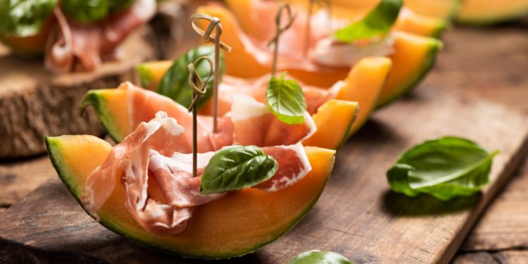 prosciutto e melone: alcune fette di melone con il prosciutto e una foglia di basilico
