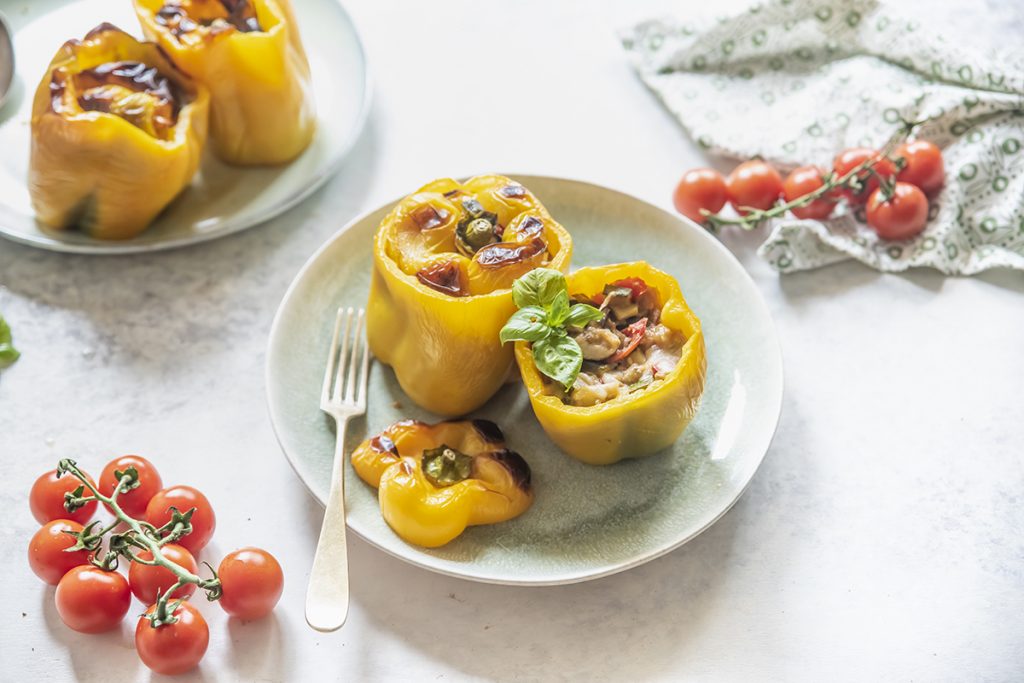 piatto bianco con due peperoni gialli ripieni di verdure