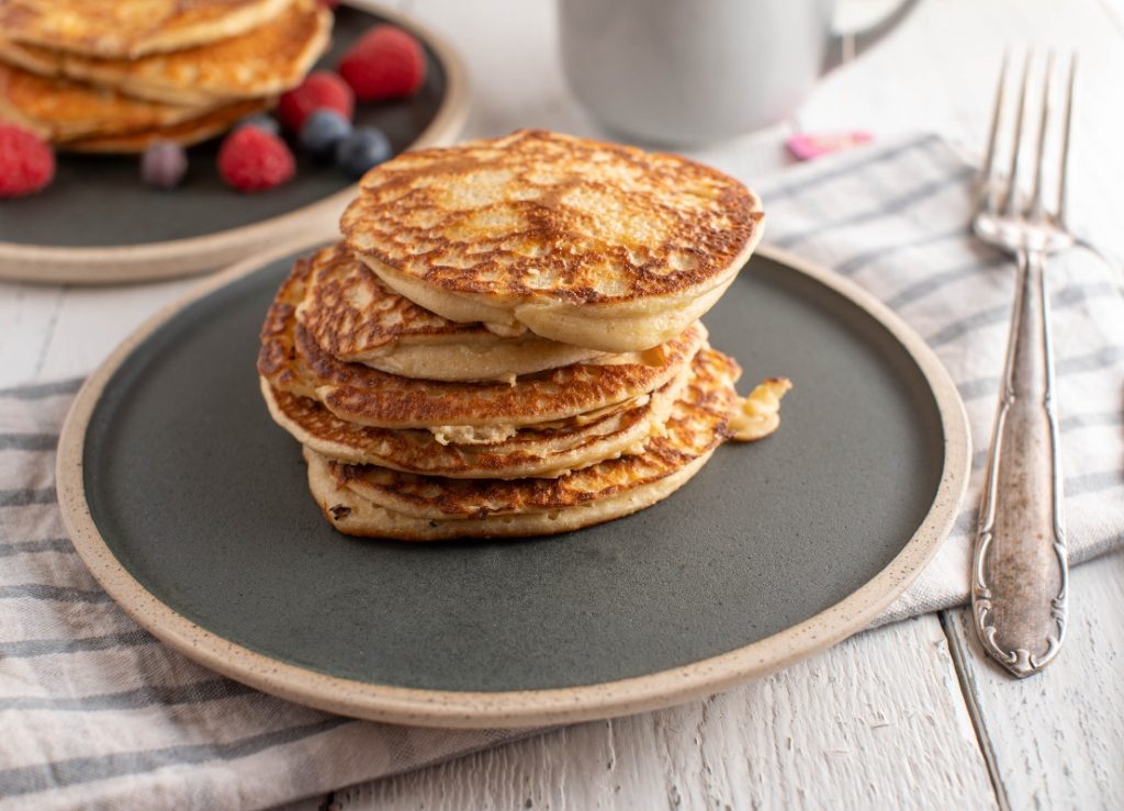 piatto tondo scuro con alcuni pancake uno sopra l'altro