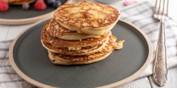 piatto tondo scuro con alcuni pancake uno sopra l'altro