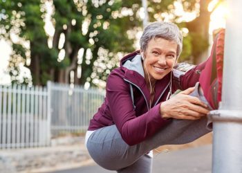 una donna cinquantenne che fa stretching per rimettersi in forma dopo i 50 anni