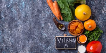 vitamina A: su base grigia carote, aranci, mela, alimenti ricchi di vitamina A