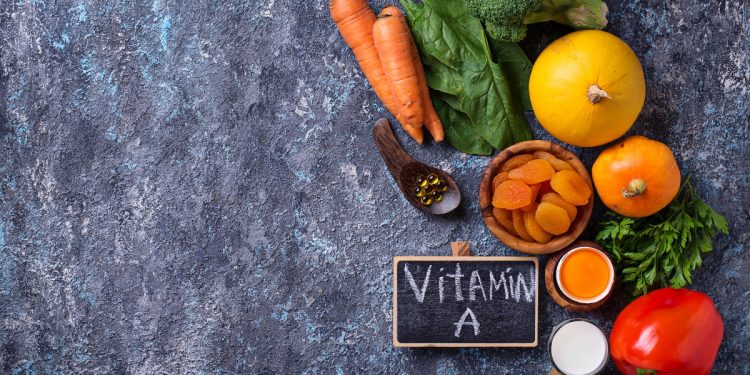 vitamina A: su base grigia carote, aranci, mela, alimenti ricchi di vitamina A