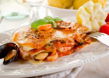 piatto bianco decorato con porzione di lasagne di pesce