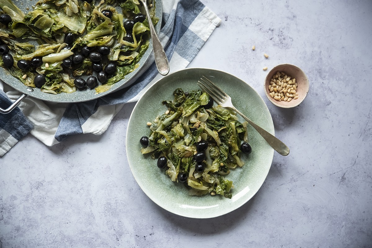 scarola saltata con alici, pinoli e olive nere 