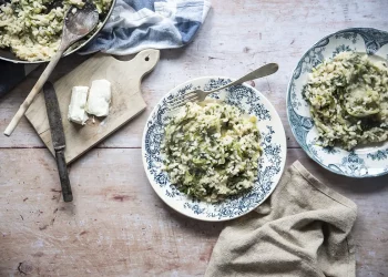 due piatti con bordi colorati con risotto di scarola, tovagliolo e forchetta