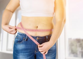 una donna che si misura con il metro la circonferenza vita