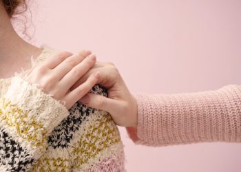 Una donna che mette la mano sulla spalla di un'altra donna in segno di conforto