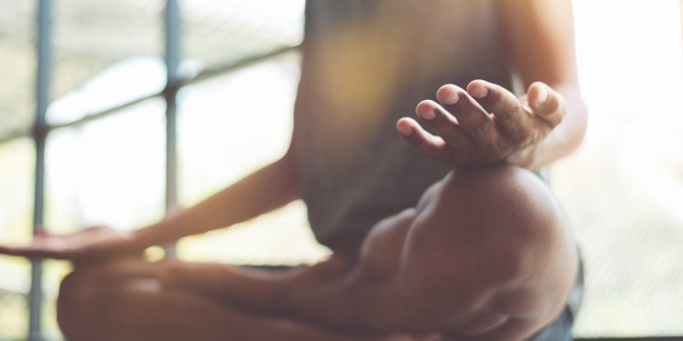 un uomo che medita nella posizione yoga del loto
