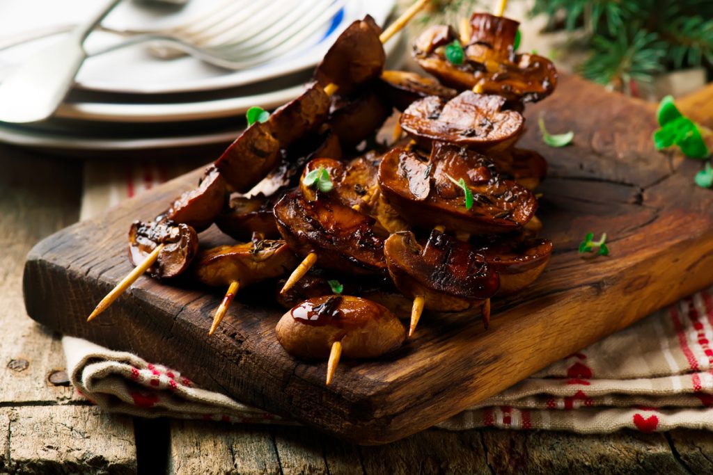 Funghi arrostiti: la ricetta alla griglia 4 vassoio di legno con spiedini di funghi arrosto