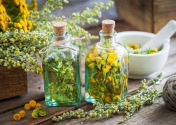 Due boccette con assenzio e dei fiori accanto