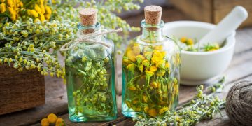 Due boccette con assenzio e dei fiori accanto