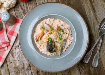 un piatto con risotto ai frutti di mare, forchetta e cucchiaio