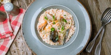 un piatto con risotto ai frutti di mare, forchetta e cucchiaio