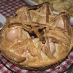 su tovaglia a quadri un casatiello napoletano con uova intere con guscio