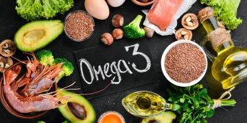 su sfondo nero alimenti come avocado, uova, semi di chia, gamberi e olio con al centro la scritta omega 3