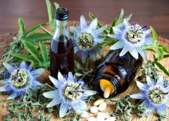 Alcuni fiori di passiflora e due boccette contenenti gocce a base di passiflora