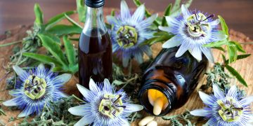 Alcuni fiori di passiflora e due boccette contenenti gocce a base di passiflora