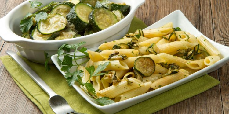 due piatti da portata, uno con penne con zucchine e l'altro con rondelle di zucchine