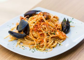 piatto bianco quadrato con porzione di spaghetti allo scoglio