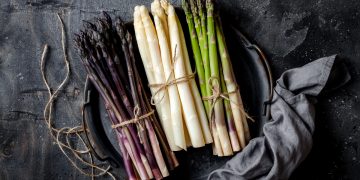 tre mazzetti di asparagi per tipologia: uno rosso, uno bianco e uno verde