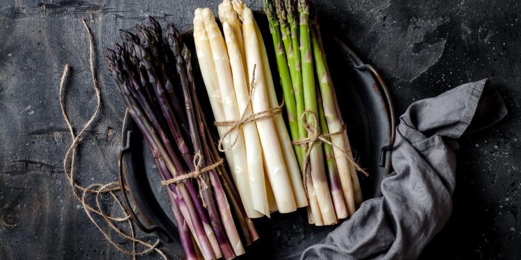 tre mazzetti di asparagi per tipologia: uno rosso, uno bianco e uno verde